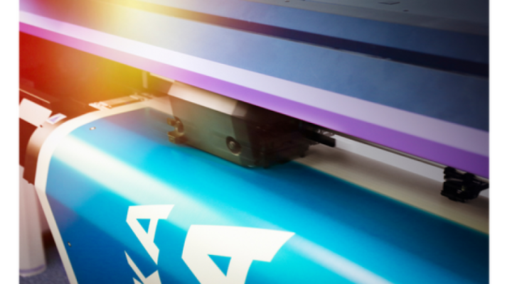 "A4" yazısının görülebildiği canlı mavi bir pankart basan büyük formatlı bir yazıcının yakın çekimi.